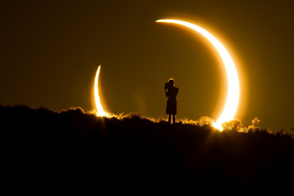 <An onlooker witnesses the annular solar eclipse as the sun sets on May 20, 2012> © Colleen Pinski. All right reserved